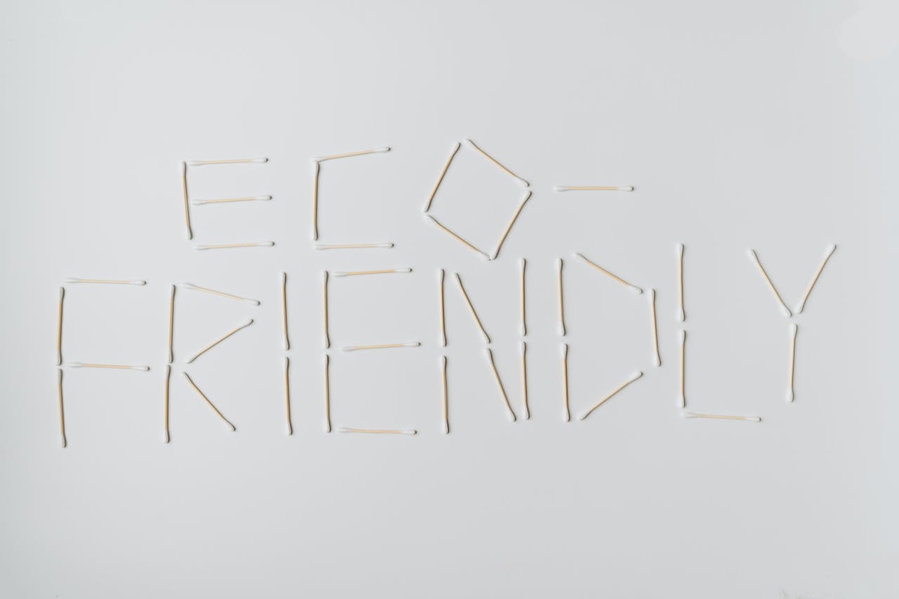 Cotton swabs spelling out eco-friendly on a clean white surface.